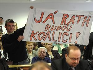 Demonstranti reagují s transparentem na slib Davida Ratha na ustavujícím zasedání středočeského zastupitelstva, které se sešlo 24. listopadu v Praze.