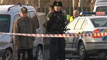 �ed� Citro�n Berlingo, ve kter�m mu� prchal, na sn�mku vedle policejn�ho vozu. Na zemi z�ejm� zakryt� mrtv� t�lo spolujezdkyn�. 